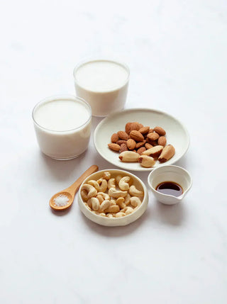 2 glasses of abc milk with small bowls of almonds and cashews