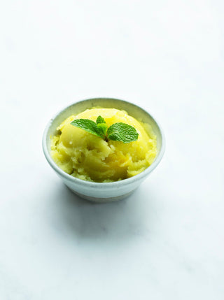 a bowl of ginger mint apple sorbet topped with a sprig of mint