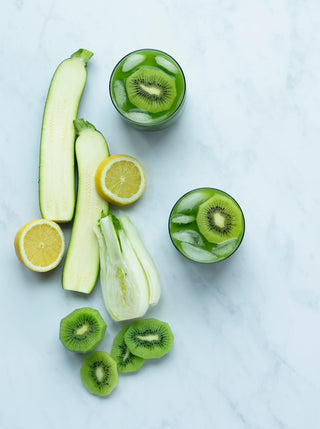 two glasses of gut loving green garnished with kiwi