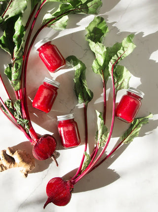 bottles of red immuni-beet shots and beet greens