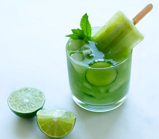 a glass of greeen juice with Cucumber Mint + Lime Popsicle