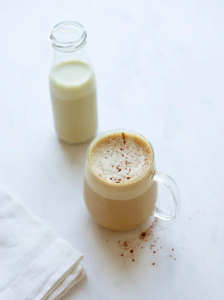 a glass and small bottle of maple pistachio mil k