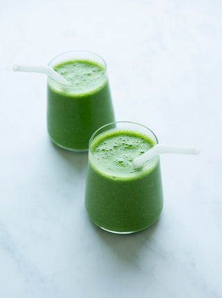 two glasses filled of match green smoothie with straws
