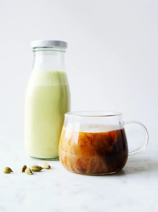 a bottle of pumpkin seed creamer with a glass cup of coffee