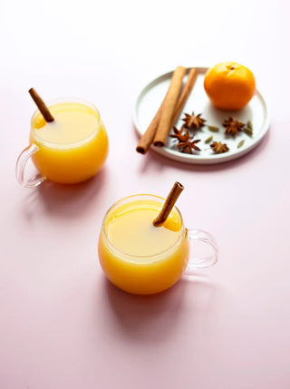 glass mugs with winter warmer juice and cinnamon sticks