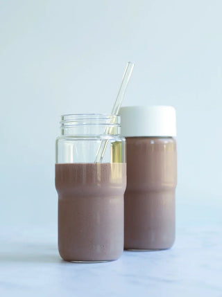 two Nama glass bottles filled with chocolate pudding shake