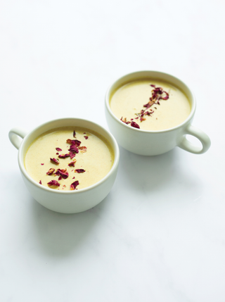 Two large cups filled with the beautiful Golden Milk and topped with cranberries