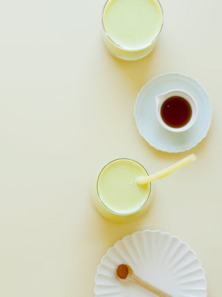 two glasses of pale yellow pumpkin seed and cashew recovery milk