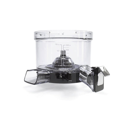 A clear plastic food processor bowl with measurement markings sits atop a black base with controls, featuring two rectangular chutes on either side for adding ingredients—similar in versatility to the Chamber Set, which utilizes a specialized chamber for efficient ingredient processing.