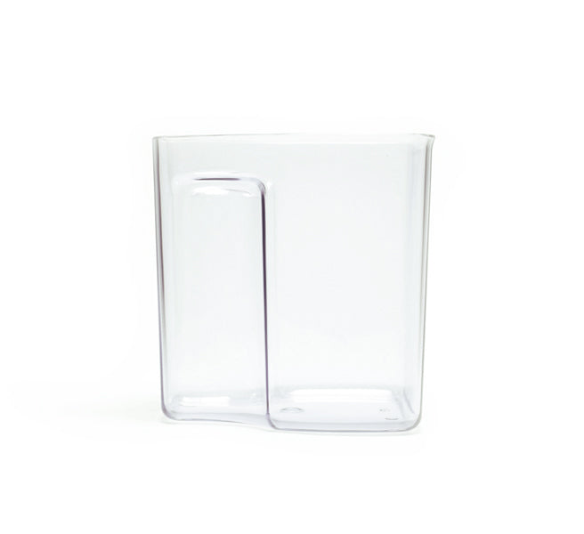 A clear, square-shaped glass with a vertical indentation running partway down one side, inspired by the sleek design of the Pulp Container from Cold Press Juicer accessories, is placed on a white background.
