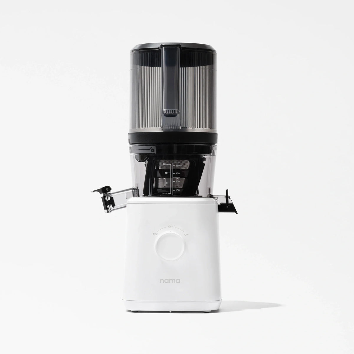A Nama J2 Cold Press Juicer in white, featuring a transparent black container with a handle and a left-side spout, is photographed against a plain white background. The Nama J2 is engineered for effortless juicing and is recognized for its easy-to-clean design.