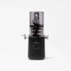 The Nama J3 cold press juicer, shown in sleek black and transparent design on a white background, features a cylindrical top chamber, dual side spouts, and a central control dial. Easy to clean and highly efficient, this portable juicer blends style with functionality for fresh juice anytime.