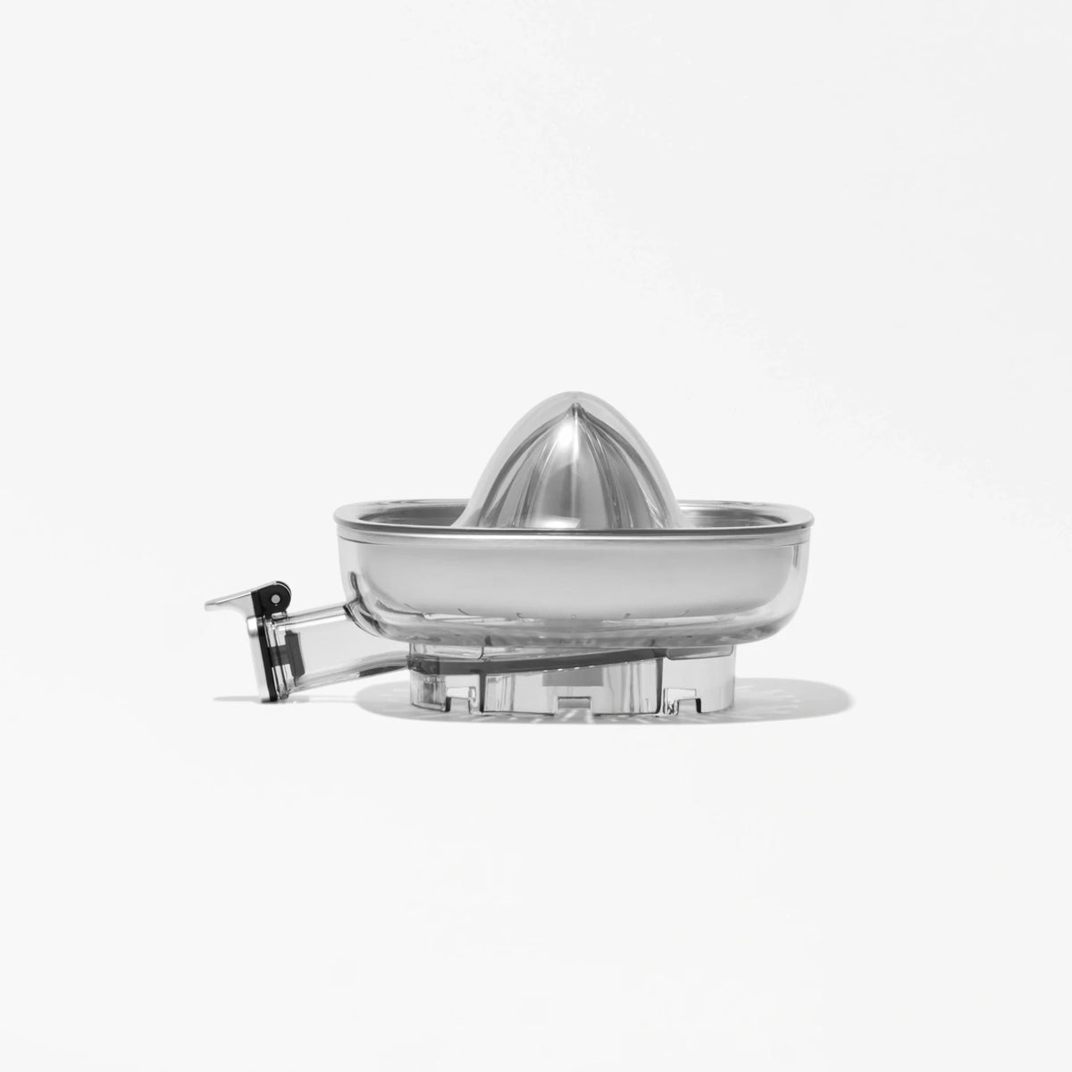 A clear, plastic Citrus Attachment with a reamer and spout is displayed on a white background. The simple and modern design of the Citrus Attachment makes juicing citrus fruits efficient, while shadows fall beneath it.