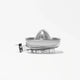 A clear, plastic Citrus Attachment with a reamer and spout is displayed on a white background. The simple and modern design of the Citrus Attachment makes juicing citrus fruits efficient, while shadows fall beneath it.