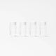 A set of four identical, clear cylindrical glass bottles from the Glass Bottle Set, each topped with a white mason jar lid, are displayed in a straight line on a plain white background. Evenly spaced and matching in design, these bottles are ideal for organized juice storage.