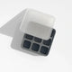 The Ice Cube Tray is made of black silicone and features eight compartments, shown with a translucent lid partially covering it and casting a shadow on a white surface.