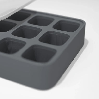 A close-up of the Ice Cube Tray, featuring six square compartments made of gray silicone, displayed on a white surface.
