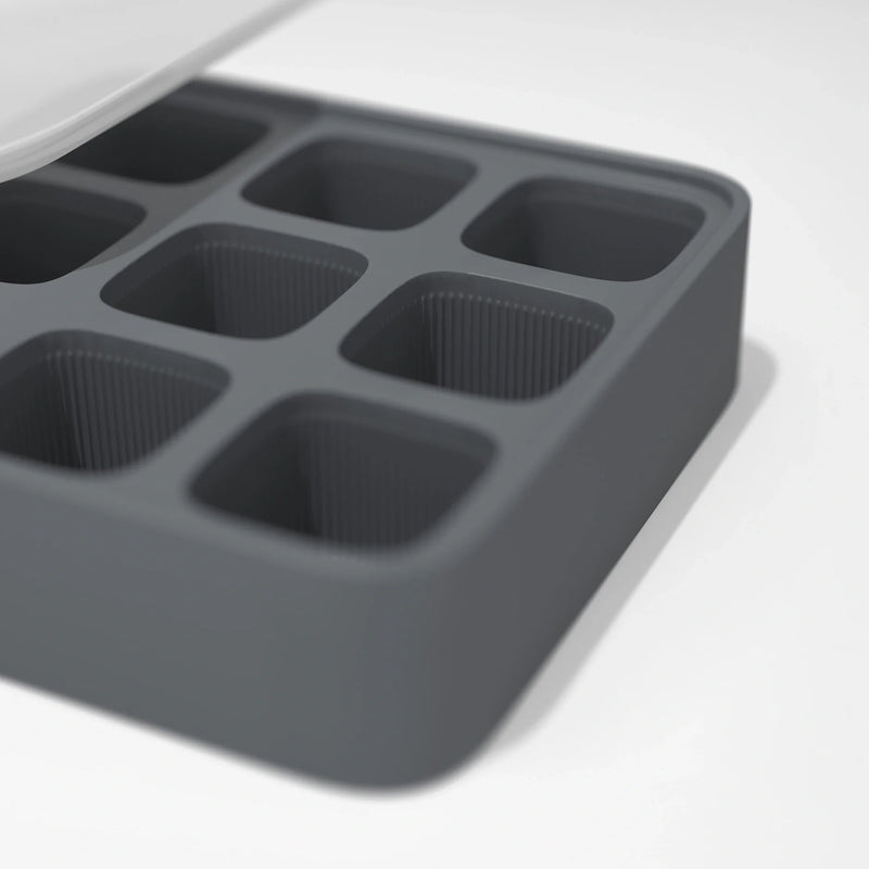 A close-up of the Ice Cube Tray, featuring six square compartments made of gray silicone, displayed on a white surface.
