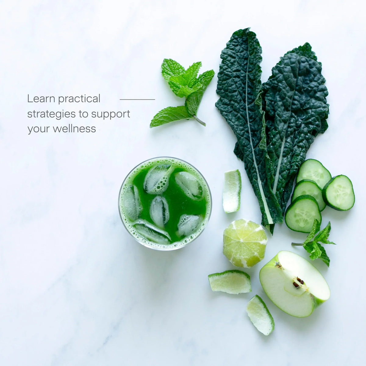 A glass of green juice with ice sits beside mint leaves, kale, cucumber slices, lime, and half an apple on a white surface. Text reads: Juicing for Balanced Blood Sugar—learn practical strategies to support your wellness.