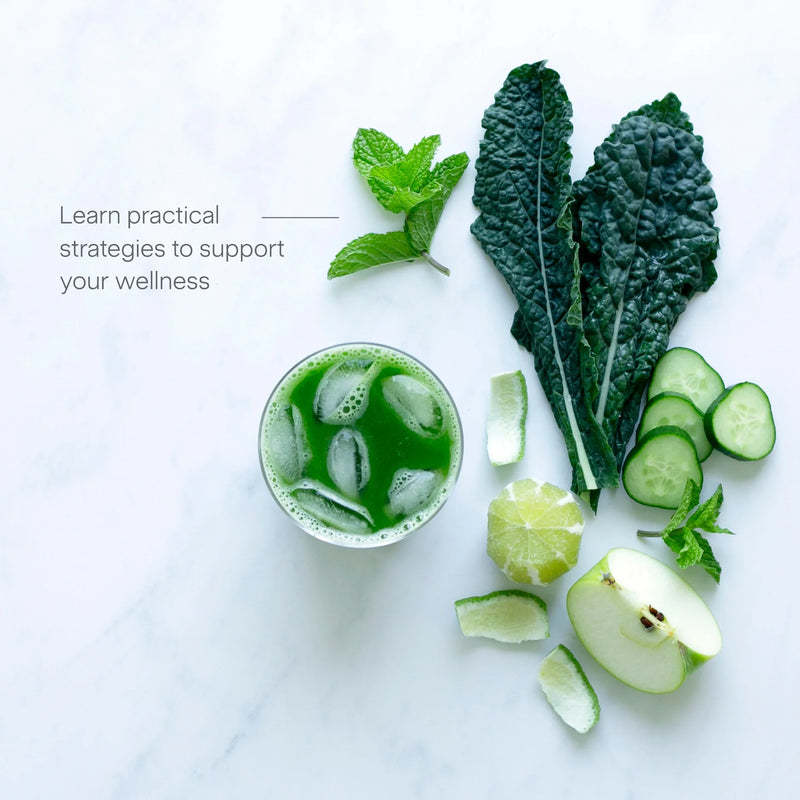 A glass of green juice with ice sits beside mint leaves, kale, cucumber slices, lime, and half an apple on a white surface. Text reads: Juicing for Balanced Blood Sugar—learn practical strategies to support your wellness.