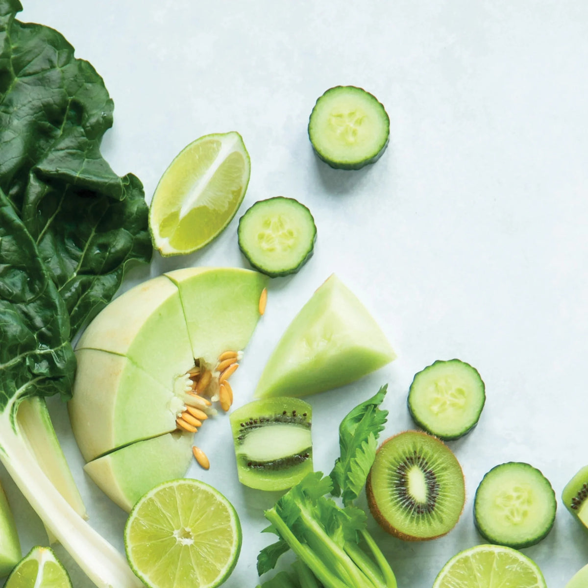 Sliced green fruits and vegetables—including kiwi, lime, cucumber, honeydew melon, leafy greens, and celery—are arranged on a light background alongside Gut Health.