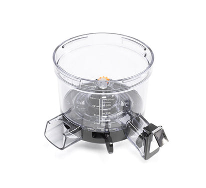 Clear plastic Chamber with measurement markings, two angled spouts, and a black base; designed for use with the Nama Vitality 5800 Cold Press Juicer as a mixing or dispensing bowl, shown against a white background.