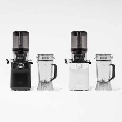 The Nama C2 juicers, in black and white, are displayed side by side on a white background with two clear plastic pitchers with lids in front of each.