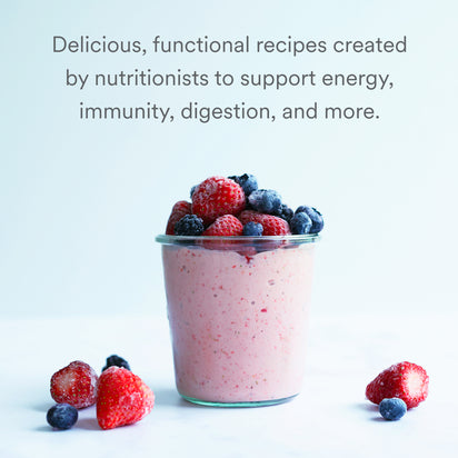 A glass jar filled with pink smoothie topped with strawberries and blueberries sits on a white surface, scattered berries nearby. Text: Blending for Beginners—nutritionist-created recipes to boost energy, immunity, digestion, and more.