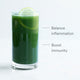 A tall glass of green juice with ice and lime slices, labeled Gut Health, is shown. Text beside it reads "Balance inflammation and boost immunity." The background is plain and light-colored.