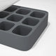 A close-up of the Nama Ice Cube Tray, featuring eight square gray silicone compartments and a transparent lid, placed on a white surface.