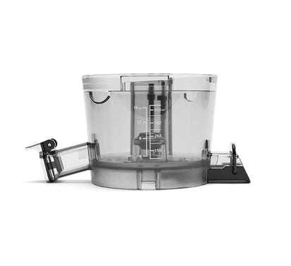 The Chamber Set features a transparent plastic measuring cup with measurement markings, a spout on the left, and a black handle on the right, displayed against a white background—perfect for complementing your juicing setup with appliances such as the Nama J2 Cold Press Juicer.