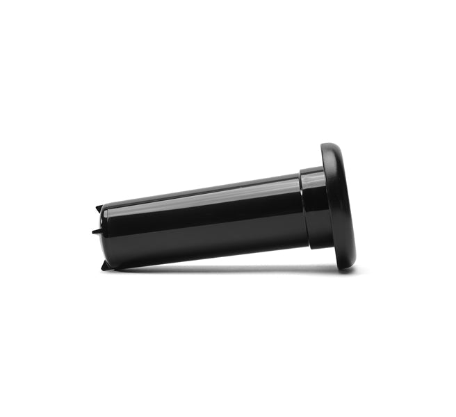 The Pusher, a black plastic cylindrical tool with a flared top and flat base designed for the Nama J2 Cold Press Juicer, is shown lying on its side against a white background.