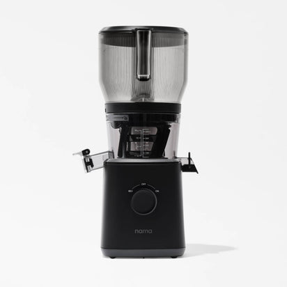 The Nama J2 XL Cold Press Juicer in black and transparent features a large top container, central spout, control knob, and side locking arms. Shown on a white background, this easy-to-clean juicer blends style with efficiency.