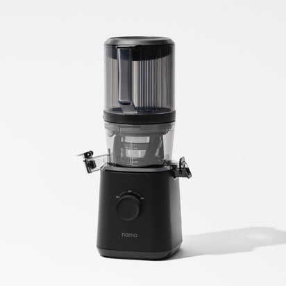 The Nama J2 is a modern black cold press juicer featuring a transparent top, central spout, side clips, and a round front control dial, displayed against a plain white background.