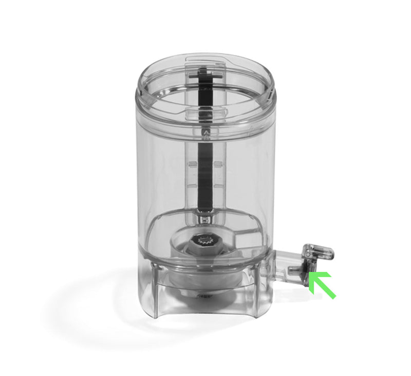 A transparent cylindrical container features a black vertical rod inside and a small spout at the base. The liquid chamber is clearly visible, with a green arrow indicating a metal valve located near the bottom. The Spout Cap Gasket securely seals the spout, preventing any leaks from the chamber.