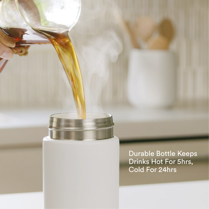 A hand pours hot coffee from a glass carafe into an Insulated On-the-Go Bottle. Text reads: Insulated On-the-Go Bottle—keeps drinks hot for 5 hours, cold for 24 hours.