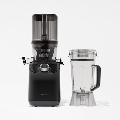 A black Nama C2 cold press juicer with a transparent top section is placed next to a clear blender container with a handle and spout, both shown against a white background.