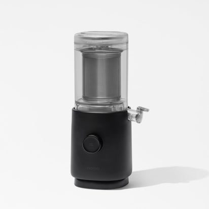 The Nama M1 Plug Type G is a modern cold brew coffee maker in black and transparent finishes, with a cylindrical design, metal filter, small spout, and shown on a plain white background—ideal for pairing with barista-quality milk.