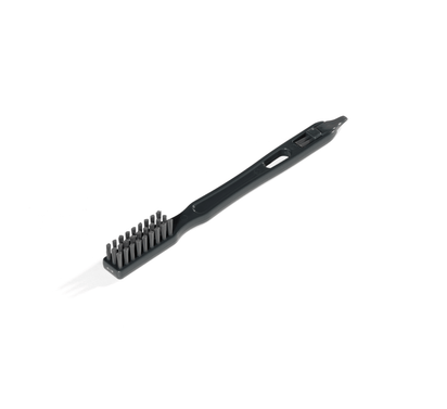 The Cleaning Brush is a black plastic tool with stiff bristles, a long handle featuring a hole at the top, and a pointed end, designed for maintaining your Nama J3 Cold Press Juicer.