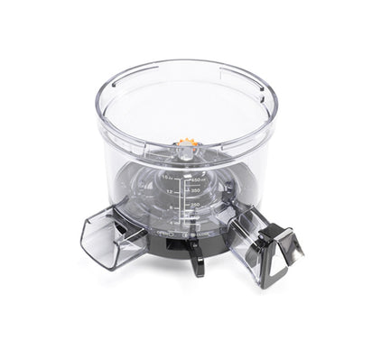 The Chamber is a transparent container with measurement markings and dual spouts, designed for precise pouring of liquids or powders. It serves as the ideal juice compartment for the Nama Vitality 5800 Cold Press Juicer.