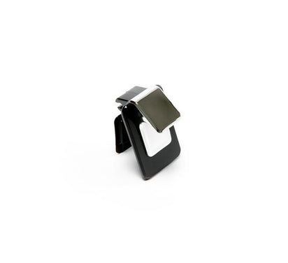 A black and white binder clip with a shiny metal clasp stands upright on a white background, echoing the sleek design of products such as the Juice Cap.