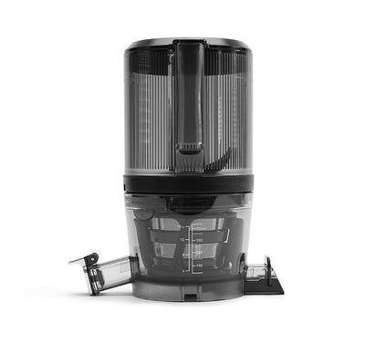 A black and transparent Chamber Set with measurement markings, a juice strainer, and two side spouts is shown on a white background—designed for use with the Nama J2 Cold Press Juicer.