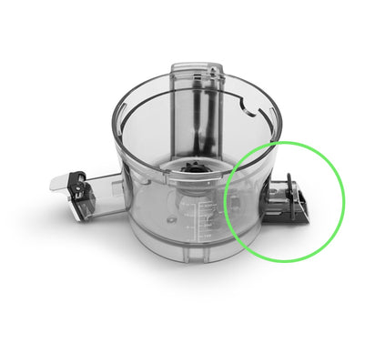 A clear plastic food processor bowl with a hinged lid and handle, featuring a green circle that highlights the Pulp Outlet Loop interlocking mechanism on the right side.