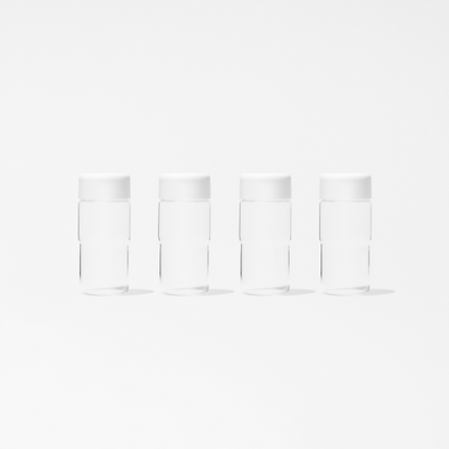 Four identical Glass Bottle Set 17-ounce bottles with white caps are evenly lined up against a plain white background, perfect for storing juice.